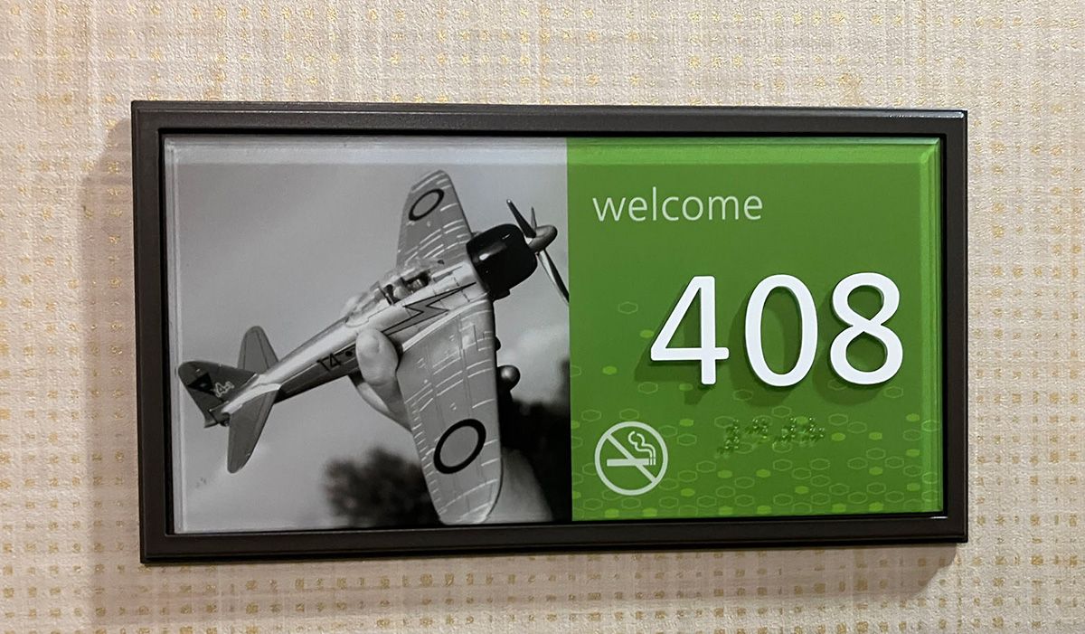 sign on door at elko hotel showing toy airplane on sign with room number